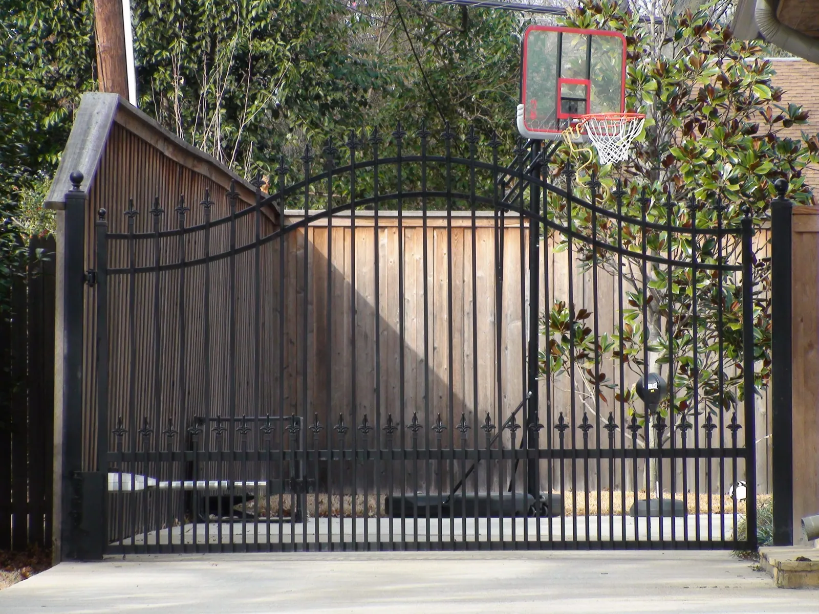 Double arched single swing electric gate with finials puppy panels — Fence Max Texas project