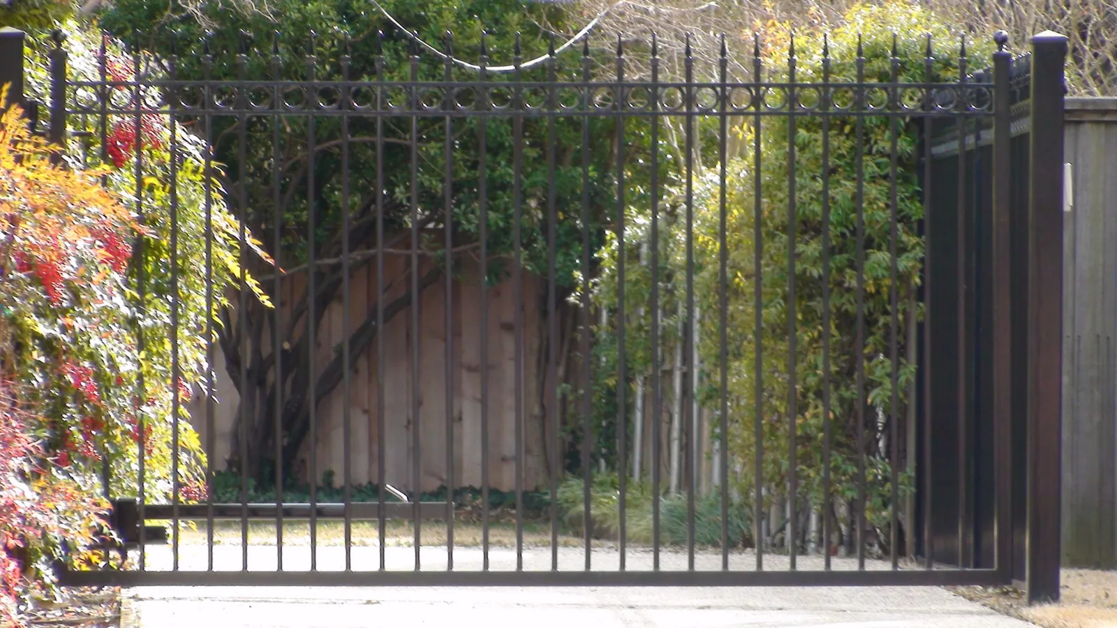 Single swing electric gate extended pickets finials rings and flat bottom — Fence Max Texas project