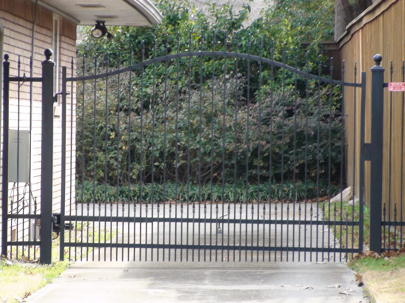 Arched single swing electric gate with finials puppy panels — Fence Max Texas project