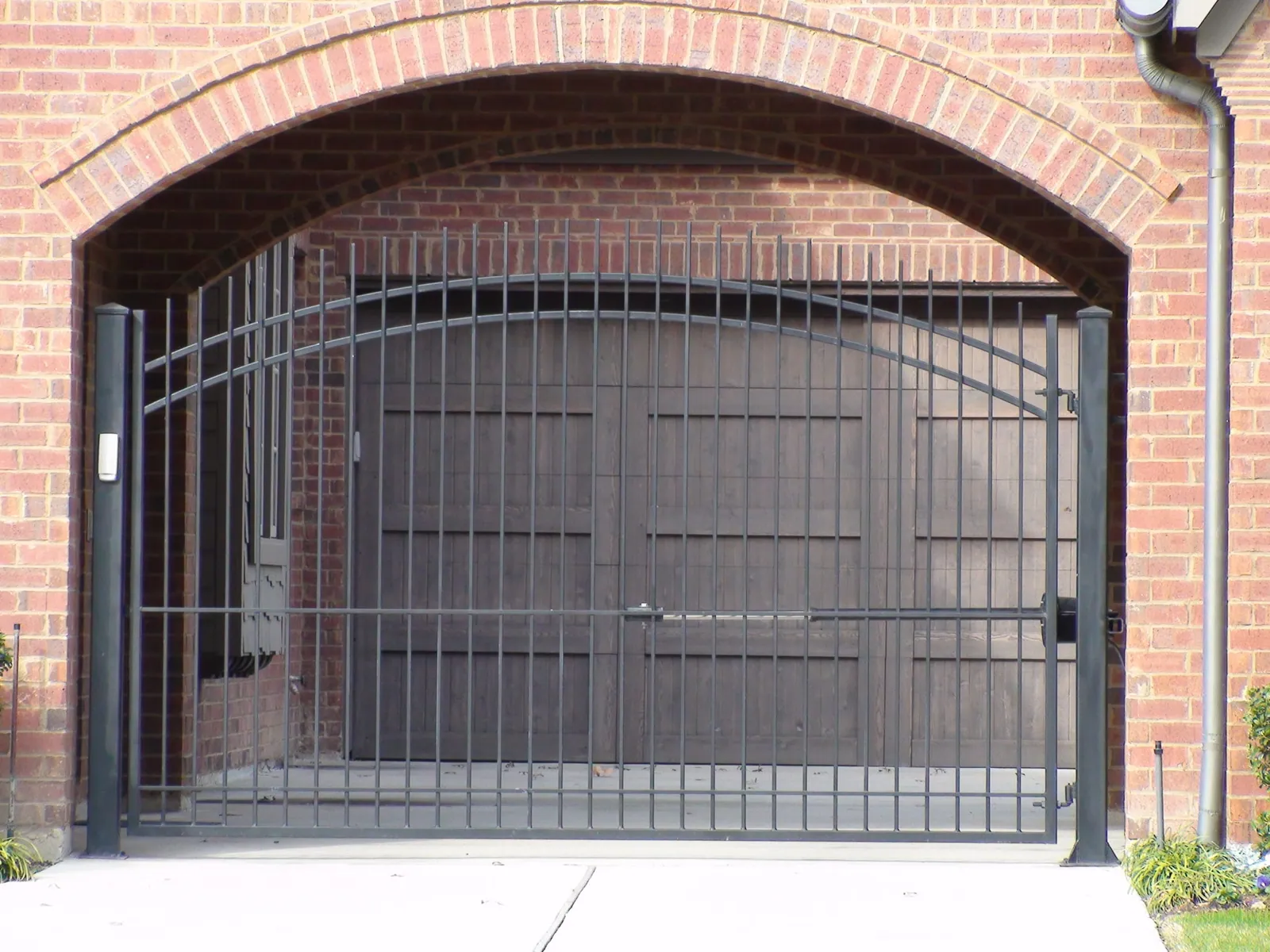 Single swing gate extended pickets inside brick arch — Fence Max Texas project