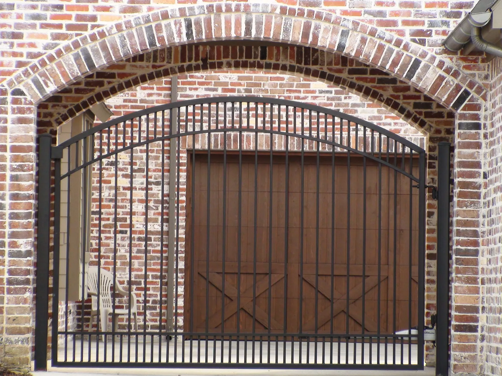 Single swing gate double arch top inside brick arch — Fence Max Texas project