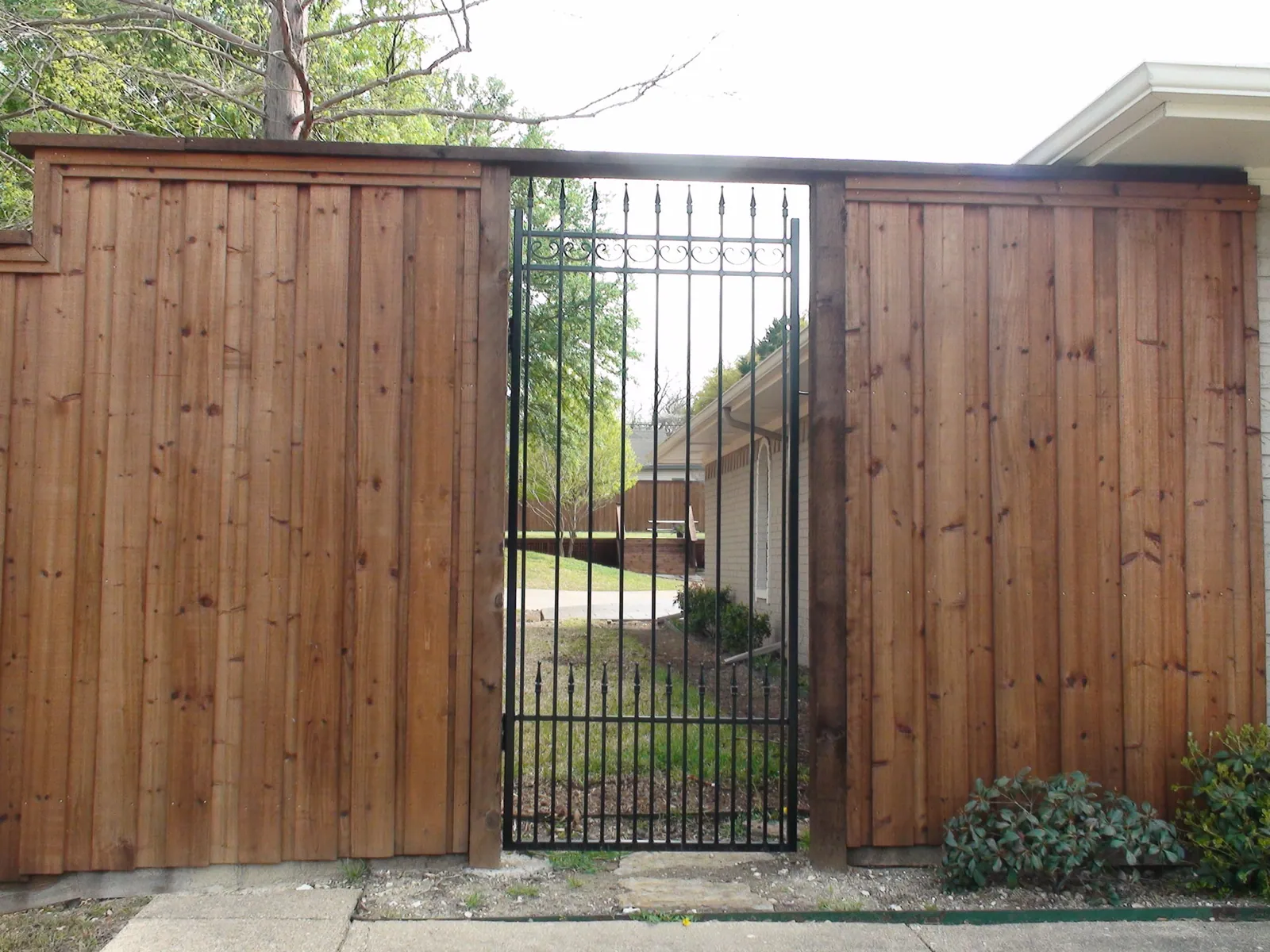 Custom iron walk in gate on b b wood fence — Fence Max Texas project
