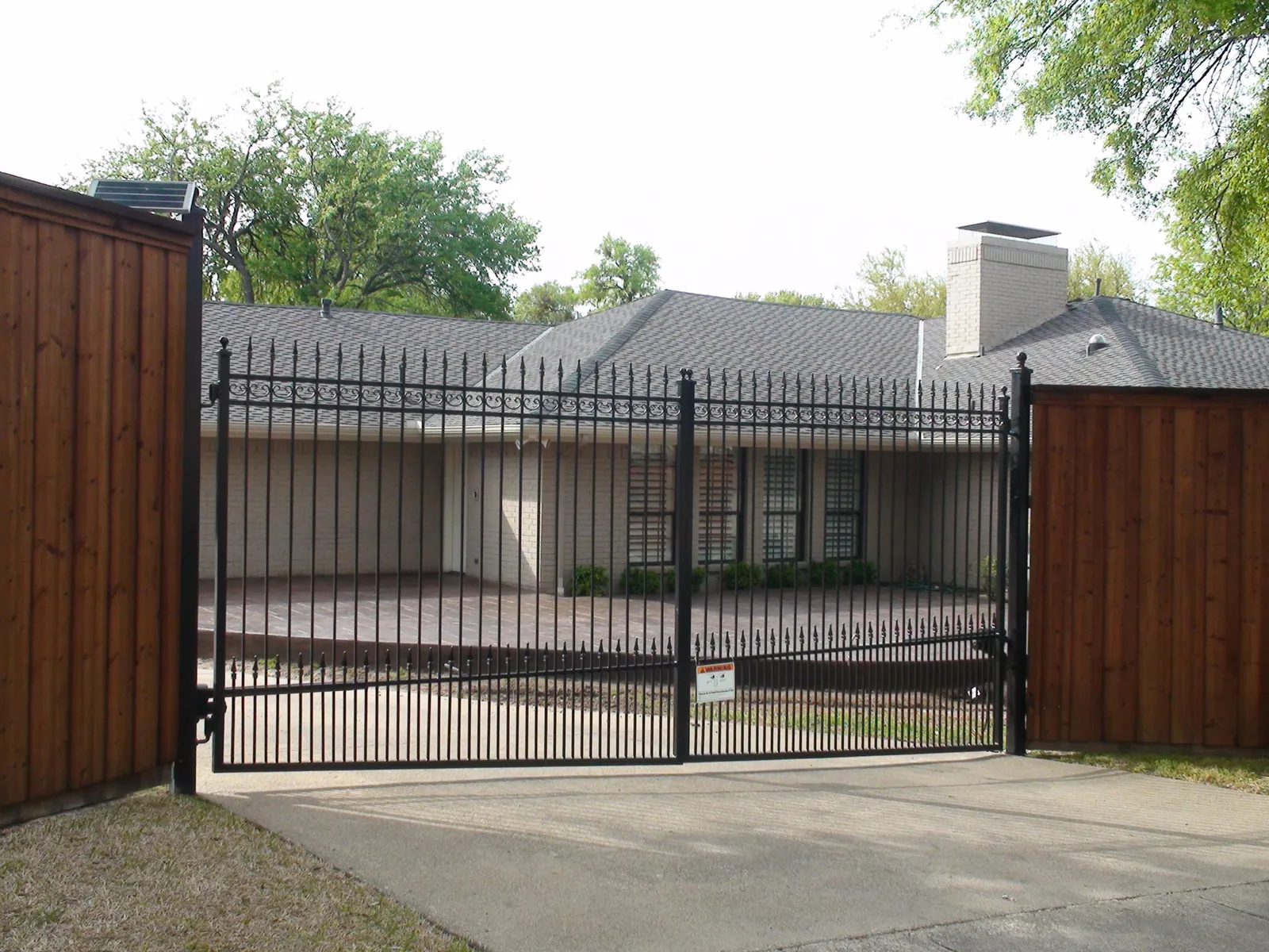 Custom double iron swing gate extended pickets. finials puppy panels b b wood fence with double trim