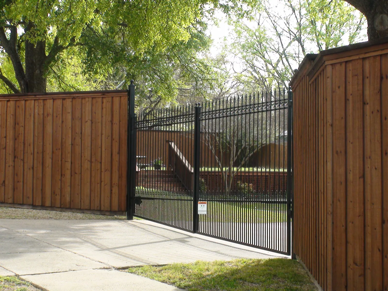 Custom double iron swing gate extended pickets. finials puppy panels b b wood fence with double trim