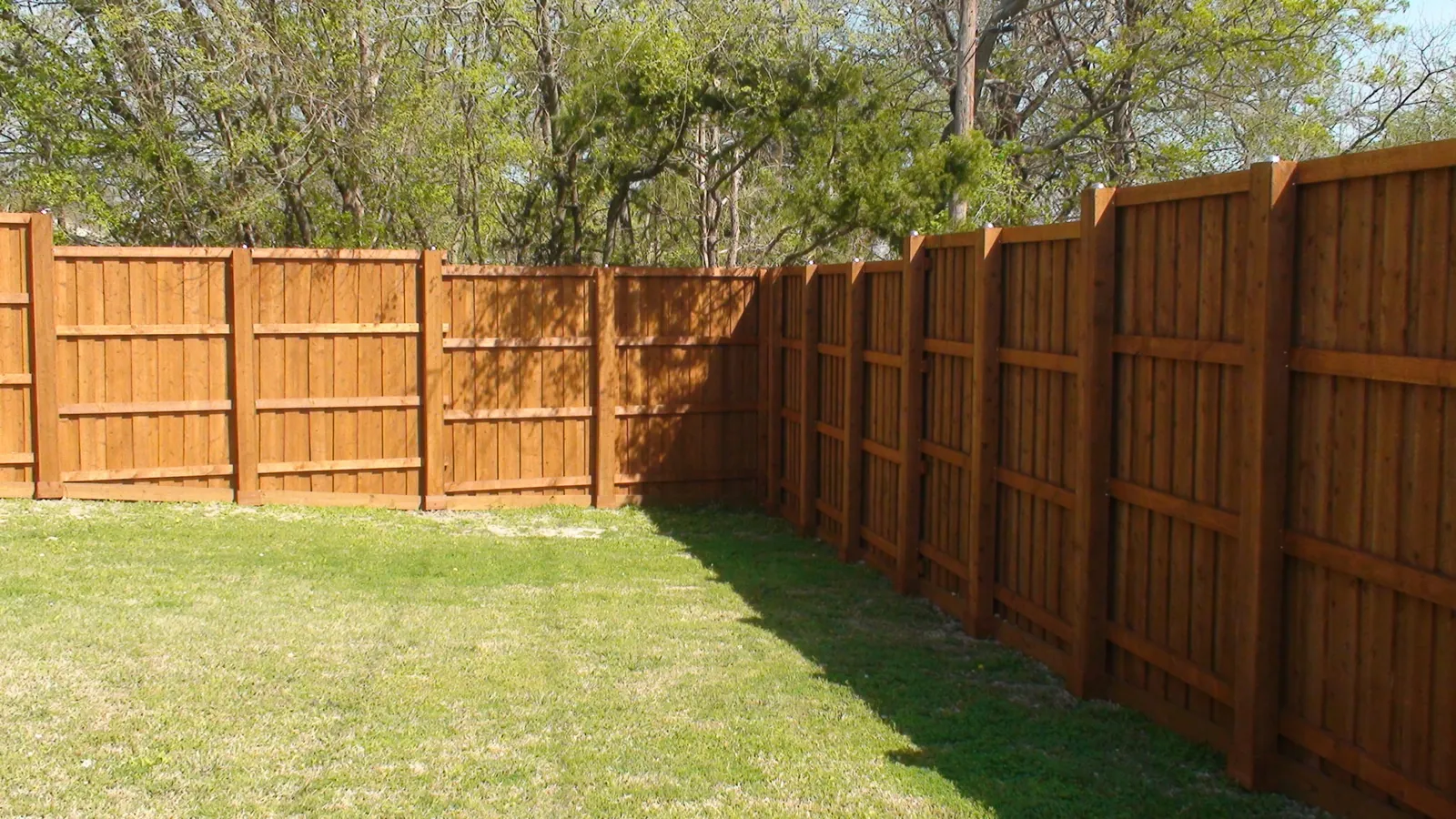 Board on board fence back side view with boxed post step level — Fence Max Texas project
