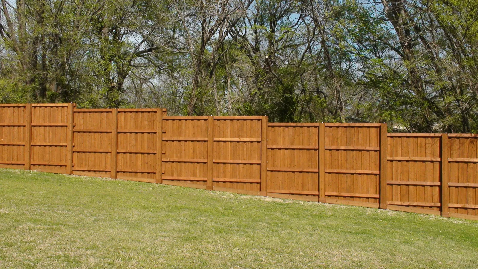 Board on board fence back side view with boxed post step level — Fence Max Texas project