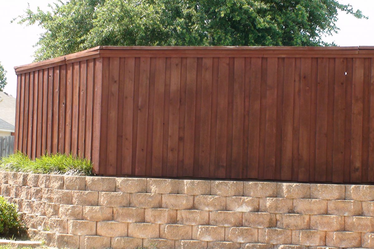 903 - Paver retaining wall with board on board fence